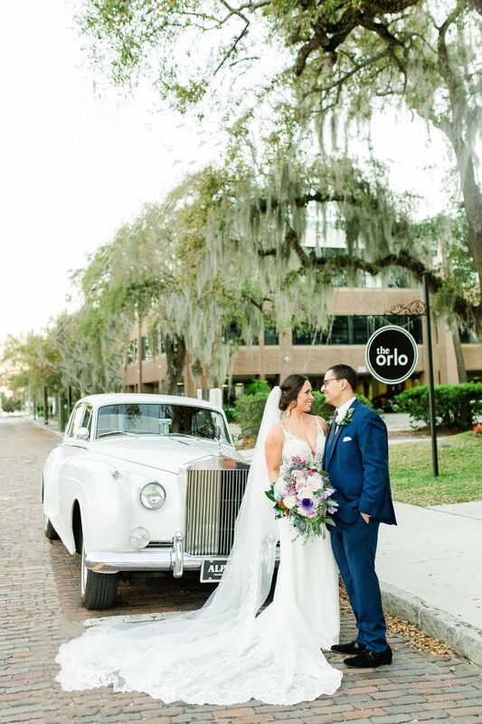 Bride and groom wedding photos with a 1979 white Rolls Royce outside the historic Orlo in Tampa Florida