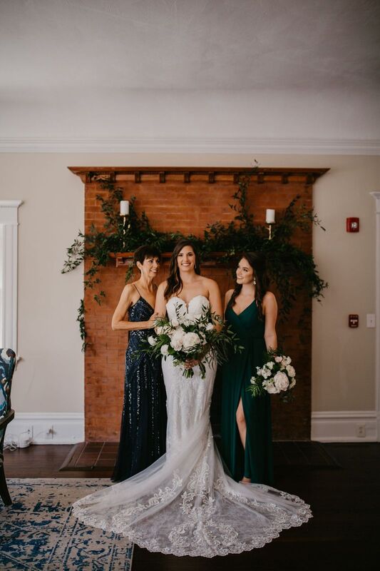 Bride with mom and sister in front of the brick fireplace at The Orlo in Tampa